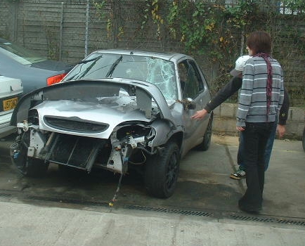 Katie looking over her wrecked car